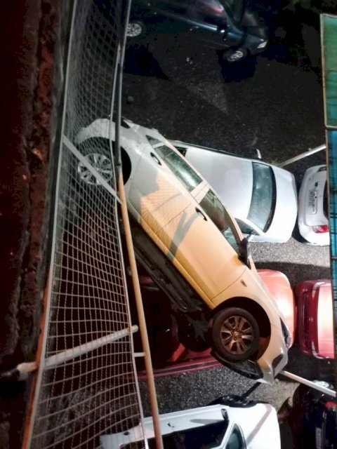 Carro cai em cima de veículos ao despencar de muro em Concórdia